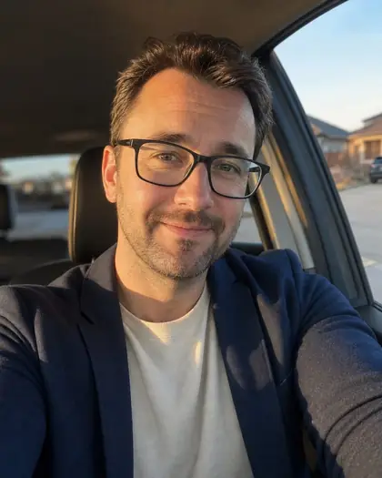 Phone selfie of Dad wearing glasses in warm car light